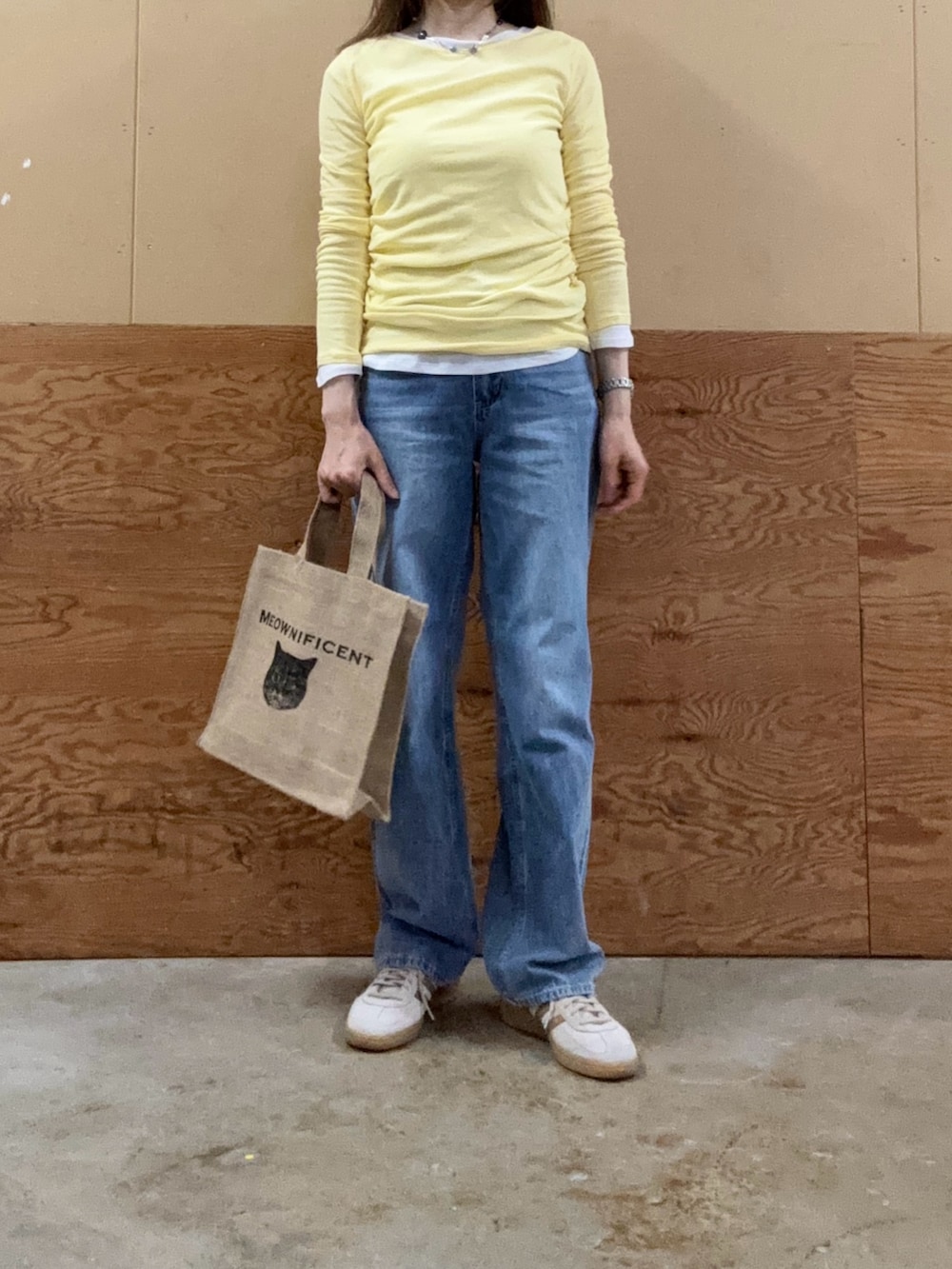 ブルー系のデニムパンツ、ブラック系のトートバッグ、ホワイト系のTシャツ/カットソーを着用したレディースの夏コーディネートの3枚目の写真
