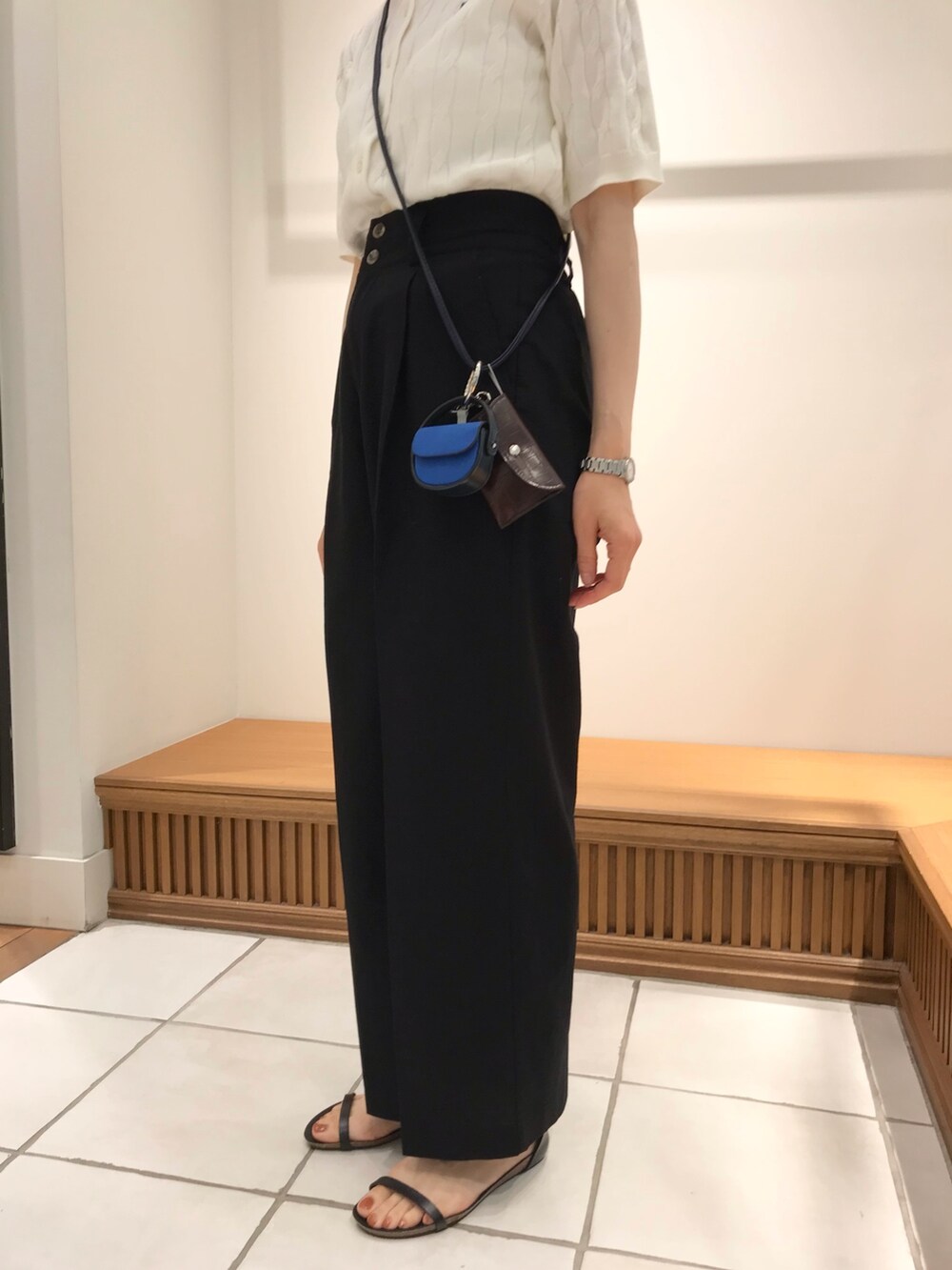 ブラック系のサンダル、ブラック系のスラックス、ホワイト系のカーディガン/ボレロを着用したレディースの夏コーディネートの3枚目の写真