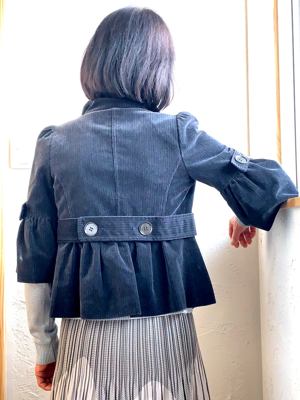 ブラック系のジャケット/アウター、シルバー系のニット/セーター、ブラック系のパンプスを着用したレディースの冬コーディネートの5枚目の写真