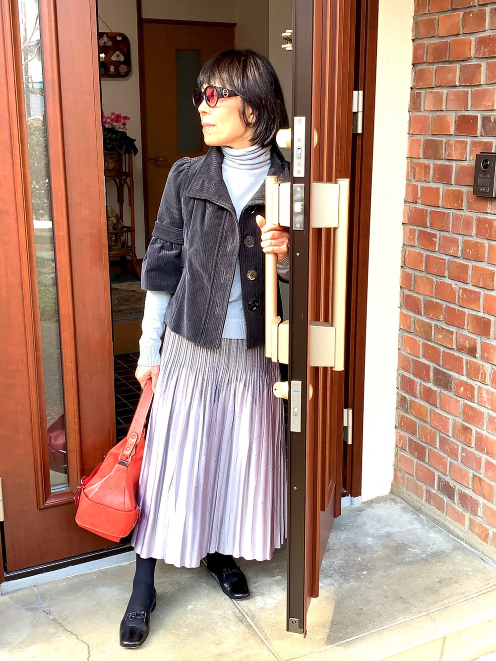 ブラック系のジャケット/アウター、シルバー系のニット/セーター、ブラック系のパンプスを着用したレディースの冬コーディネートの3枚目の写真