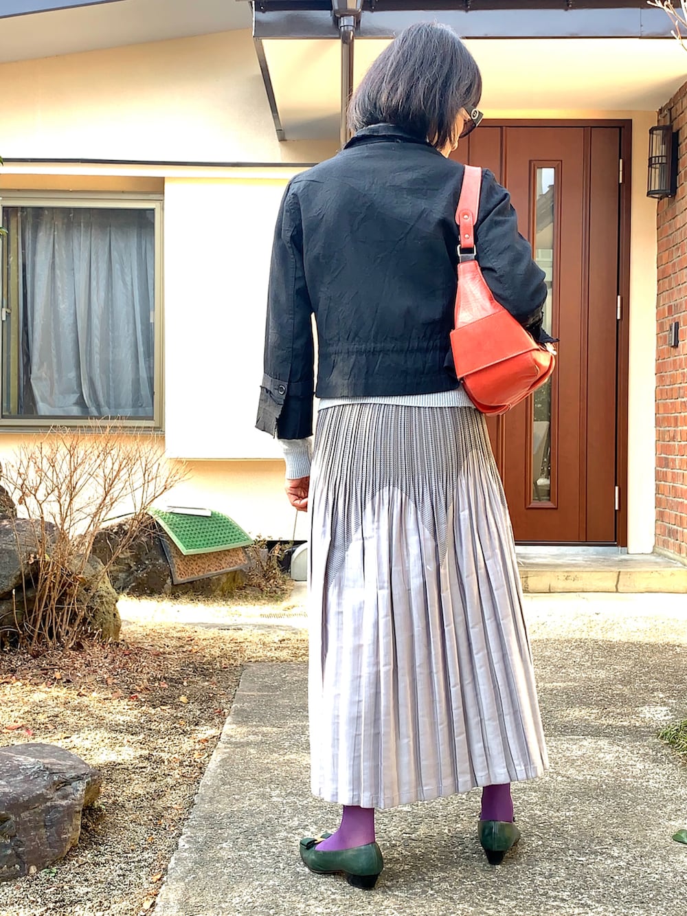 ブラック系のジャケット/アウター、シルバー系のスカート、グリーン系のパンプスを着用したレディースの冬コーディネートの2枚目の写真