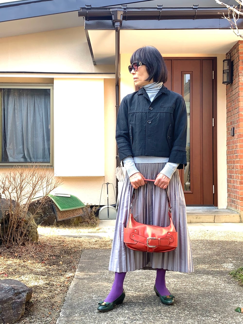 ブラック系のジャケット/アウター、シルバー系のスカート、グリーン系のパンプスを着用したレディースの冬コーディネートの3枚目の写真