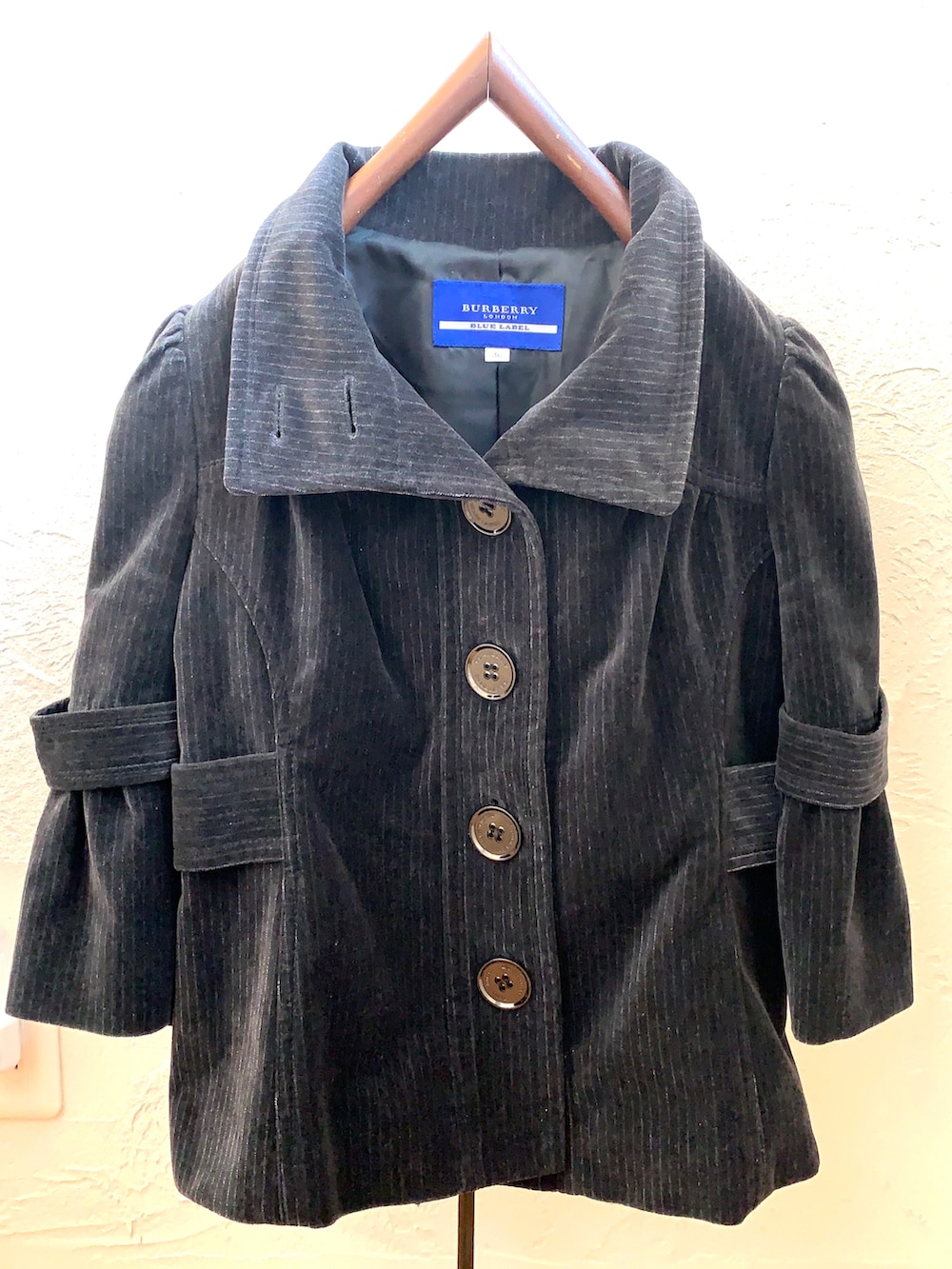 ブラック系のジャケット/アウター、シルバー系のニット/セーター、ブラック系のパンプスを着用したレディースの冬コーディネートの4枚目の写真