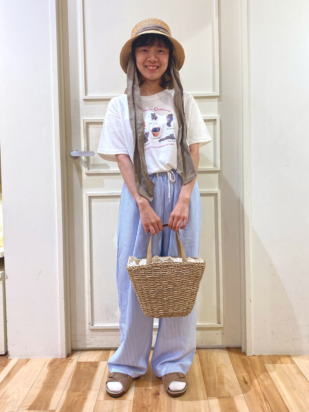 ブルー系のパンツ、ベージュ系のハンドバッグ、ホワイト系のTシャツ/カットソーを着用したレディースの春コーディネートの2枚目の写真