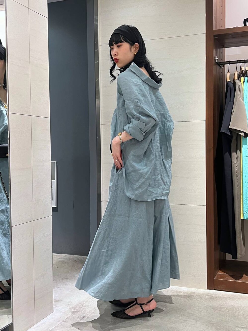 グリーン系のシャツ/ブラウス、グリーン系のスカート、ブラック系のパンプスを着用したレディースの春コーディネートの2枚目の写真