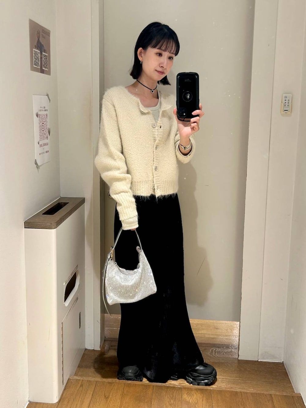 ホワイト系のTシャツ/カットソー、ブラック系のブーツ、シルバー系のハンドバッグを着用したレディースの冬コーディネートの2枚目の写真