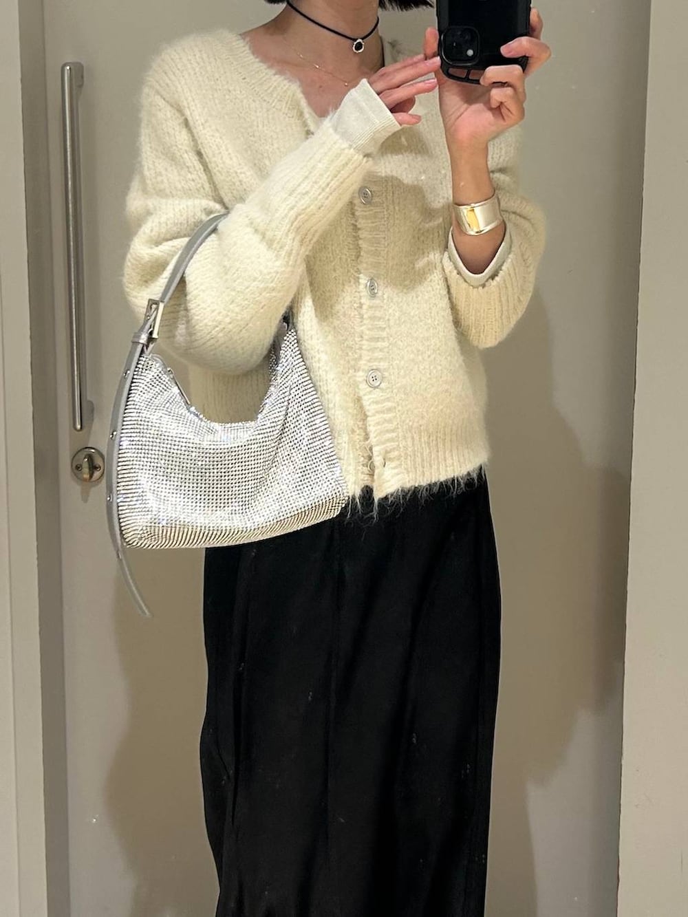 ホワイト系のTシャツ/カットソー、ブラック系のブーツ、シルバー系のハンドバッグを着用したレディースの冬コーディネートの4枚目の写真