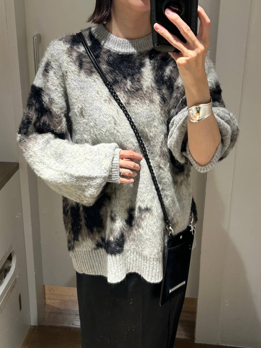 グレー系のニット/セーター、ブラック系のブーツ、ブラック系のスカートを着用したレディースの秋コーディネートの4枚目の写真