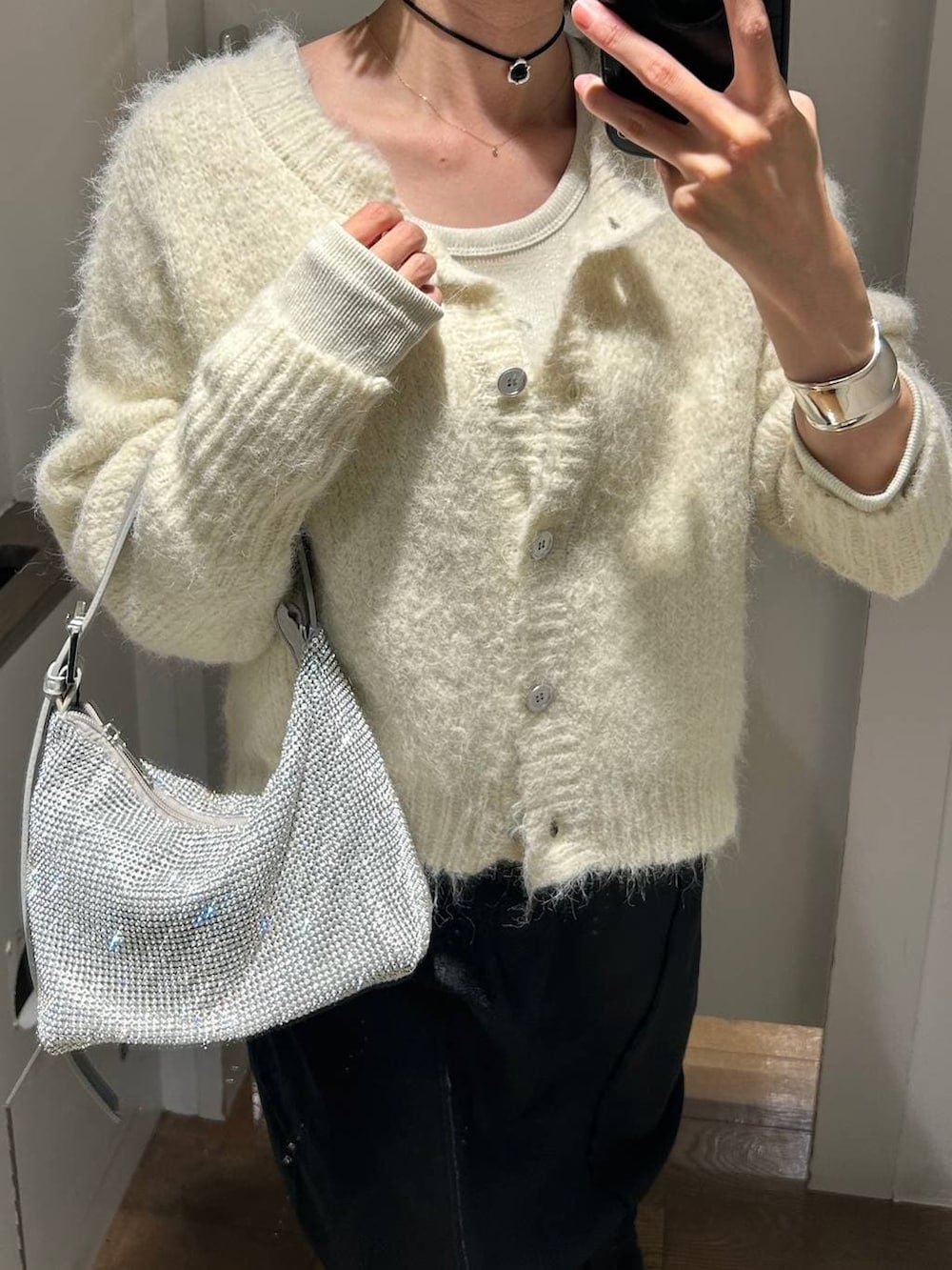 ホワイト系のTシャツ/カットソー、ブラック系のブーツ、シルバー系のハンドバッグを着用したレディースの冬コーディネートの3枚目の写真