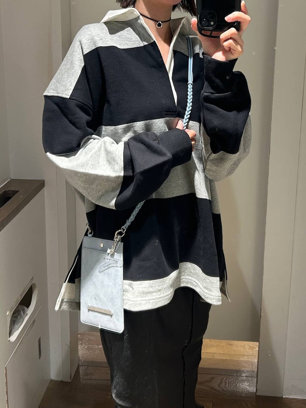 ブラック系のブーツ、グレー系のポロシャツ、ブラック系のスカートを着用したレディースの冬コーディネートの4枚目の写真