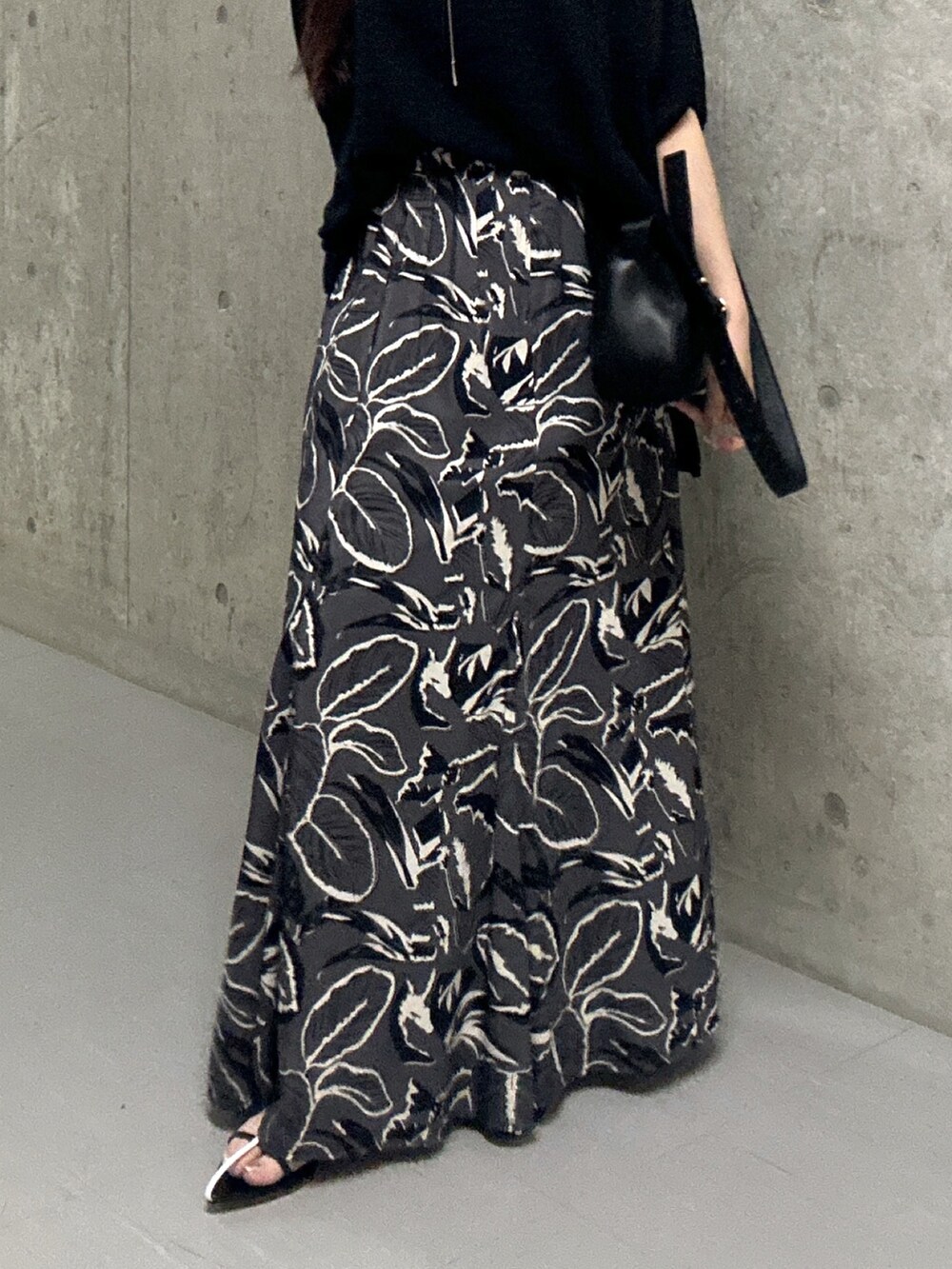 ブラック系のスカート、ブラック系のサンダル、ブラック系のハンドバッグを着用したレディースの夏コーディネートの7枚目の写真