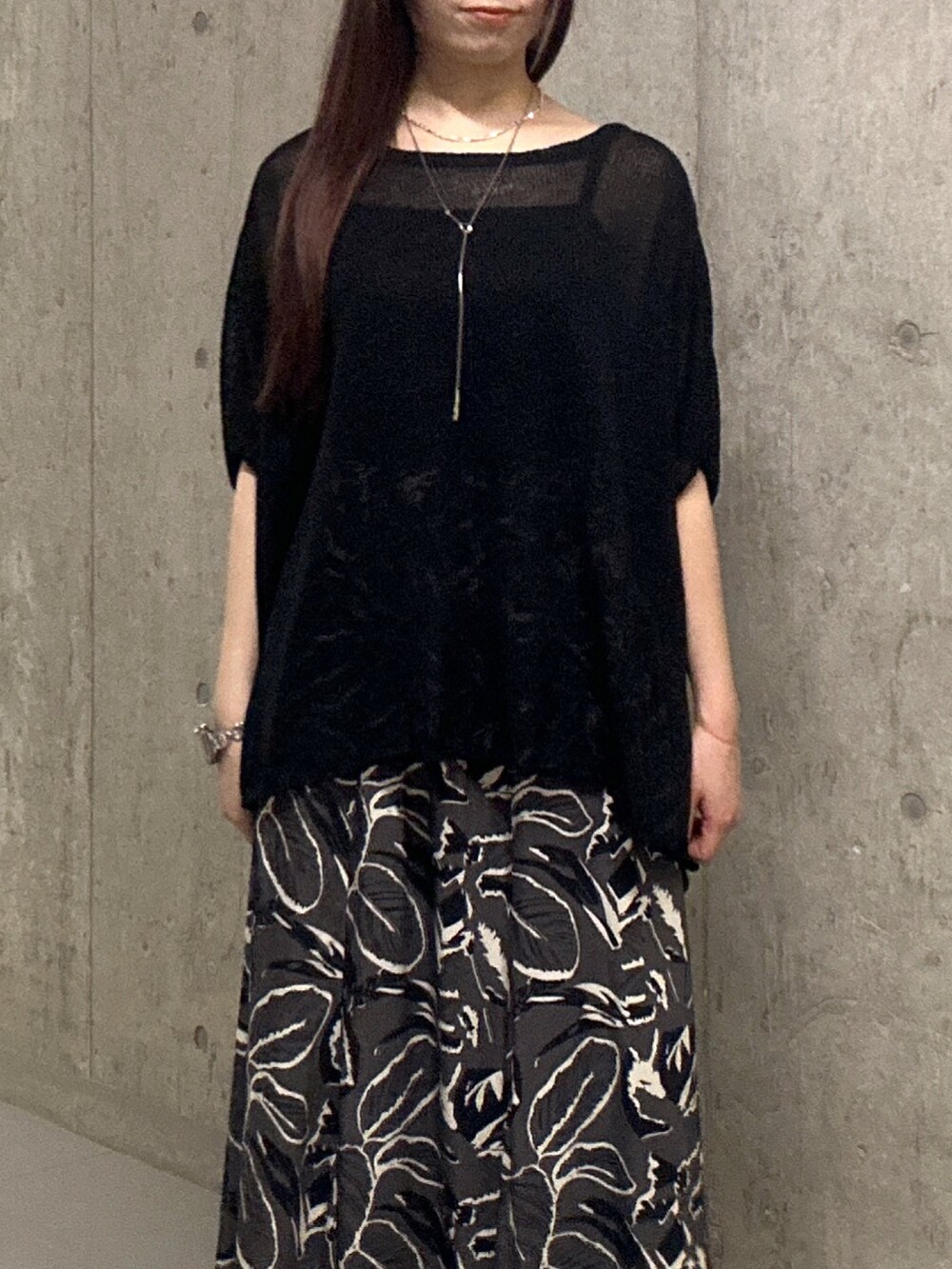 ブラック系のスカート、ブラック系のサンダル、ブラック系のハンドバッグを着用したレディースの夏コーディネートの4枚目の写真