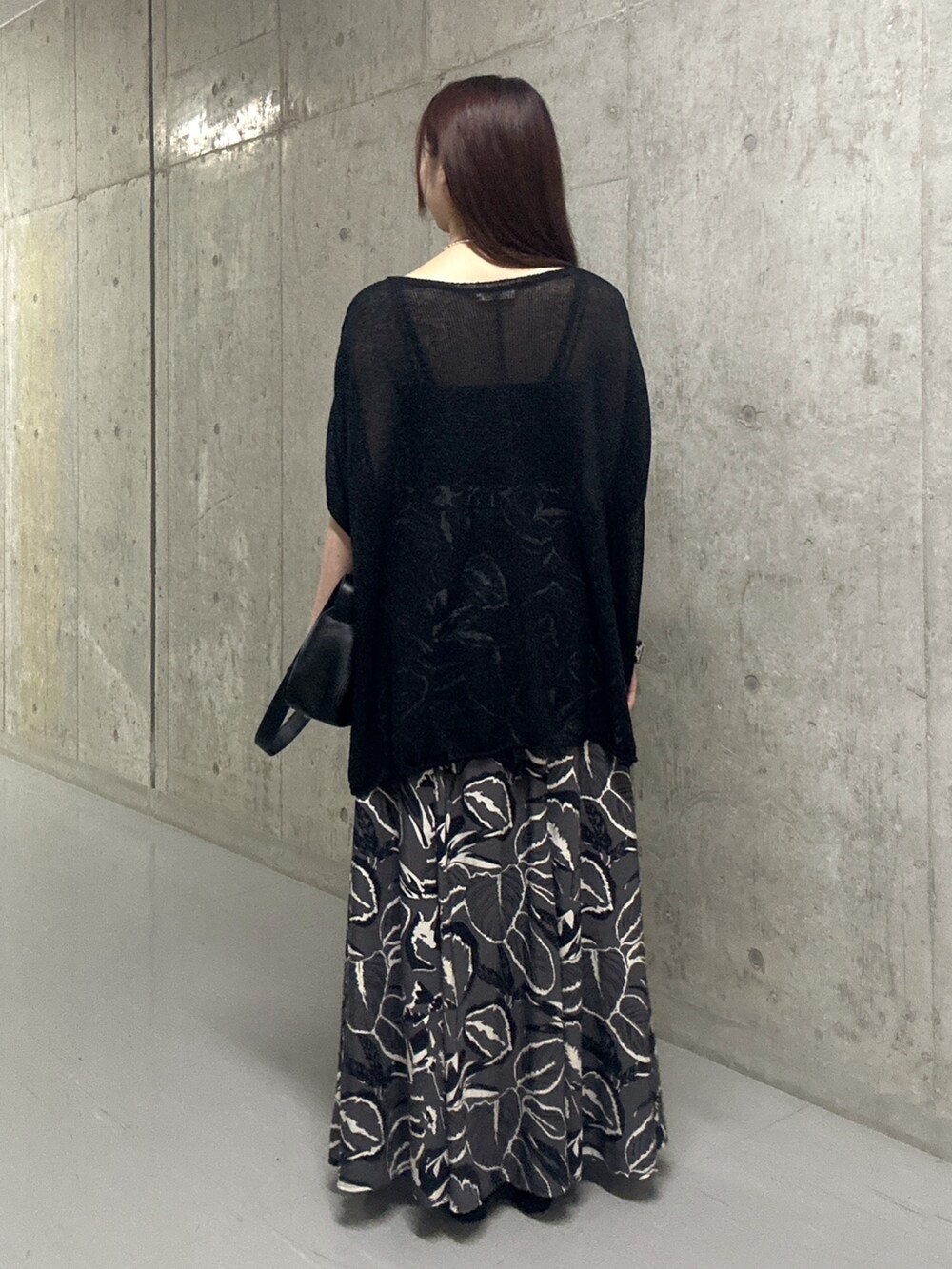 ブラック系のスカート、ブラック系のサンダル、ブラック系のハンドバッグを着用したレディースの夏コーディネートの3枚目の写真