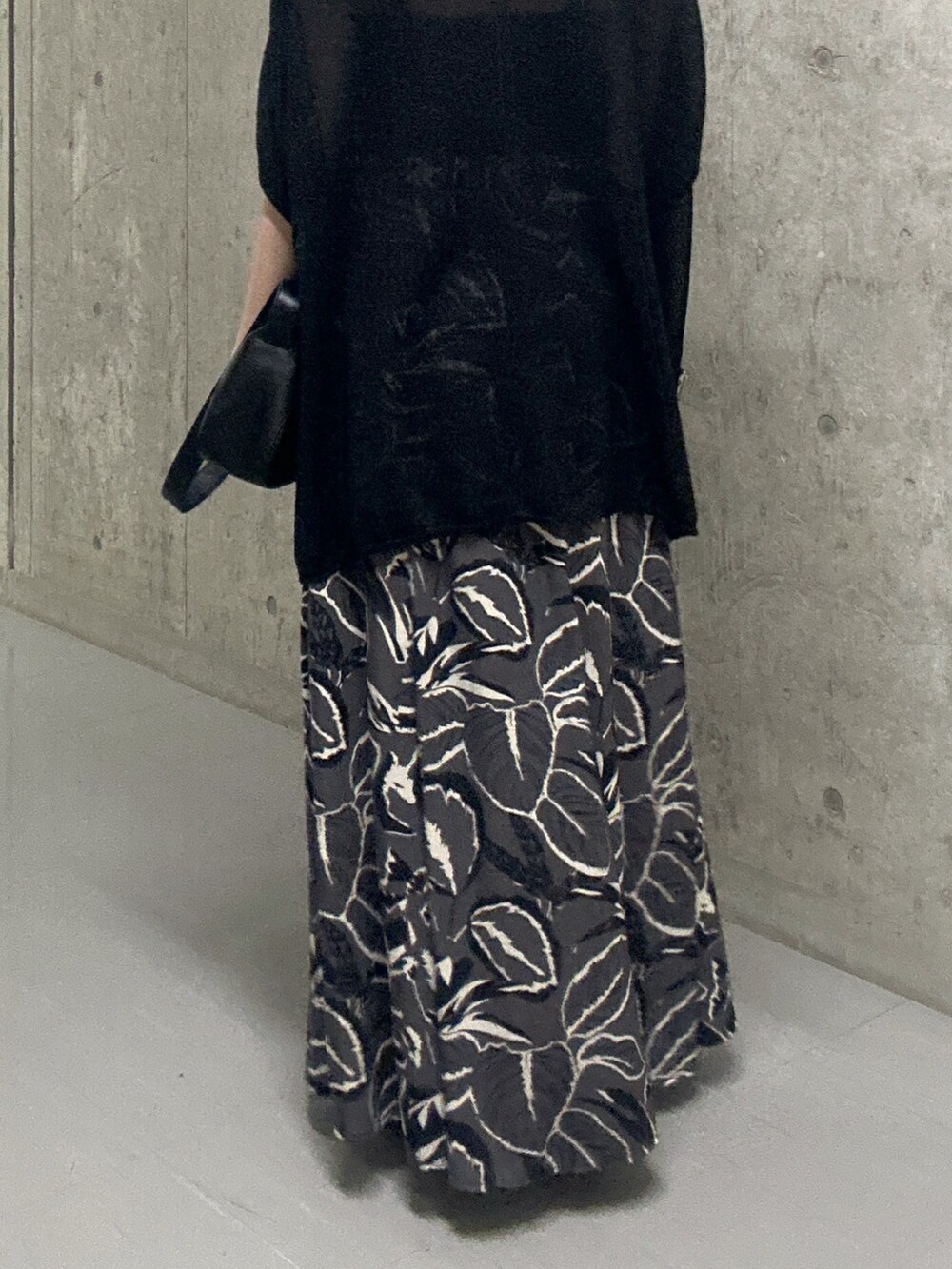 ブラック系のスカート、ブラック系のサンダル、ブラック系のハンドバッグを着用したレディースの夏コーディネートの9枚目の写真