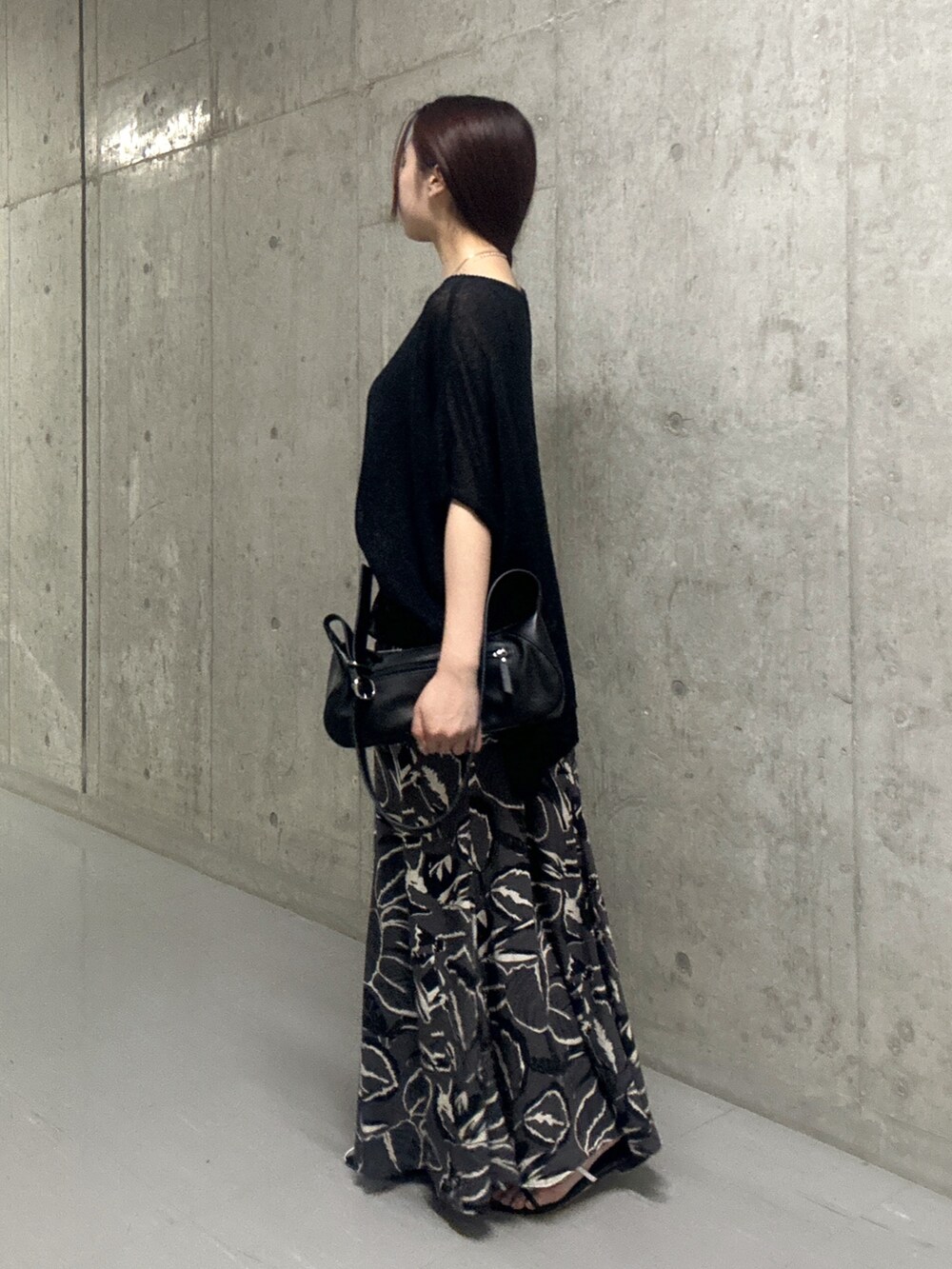 ブラック系のスカート、ブラック系のサンダル、ブラック系のハンドバッグを着用したレディースの夏コーディネートの2枚目の写真