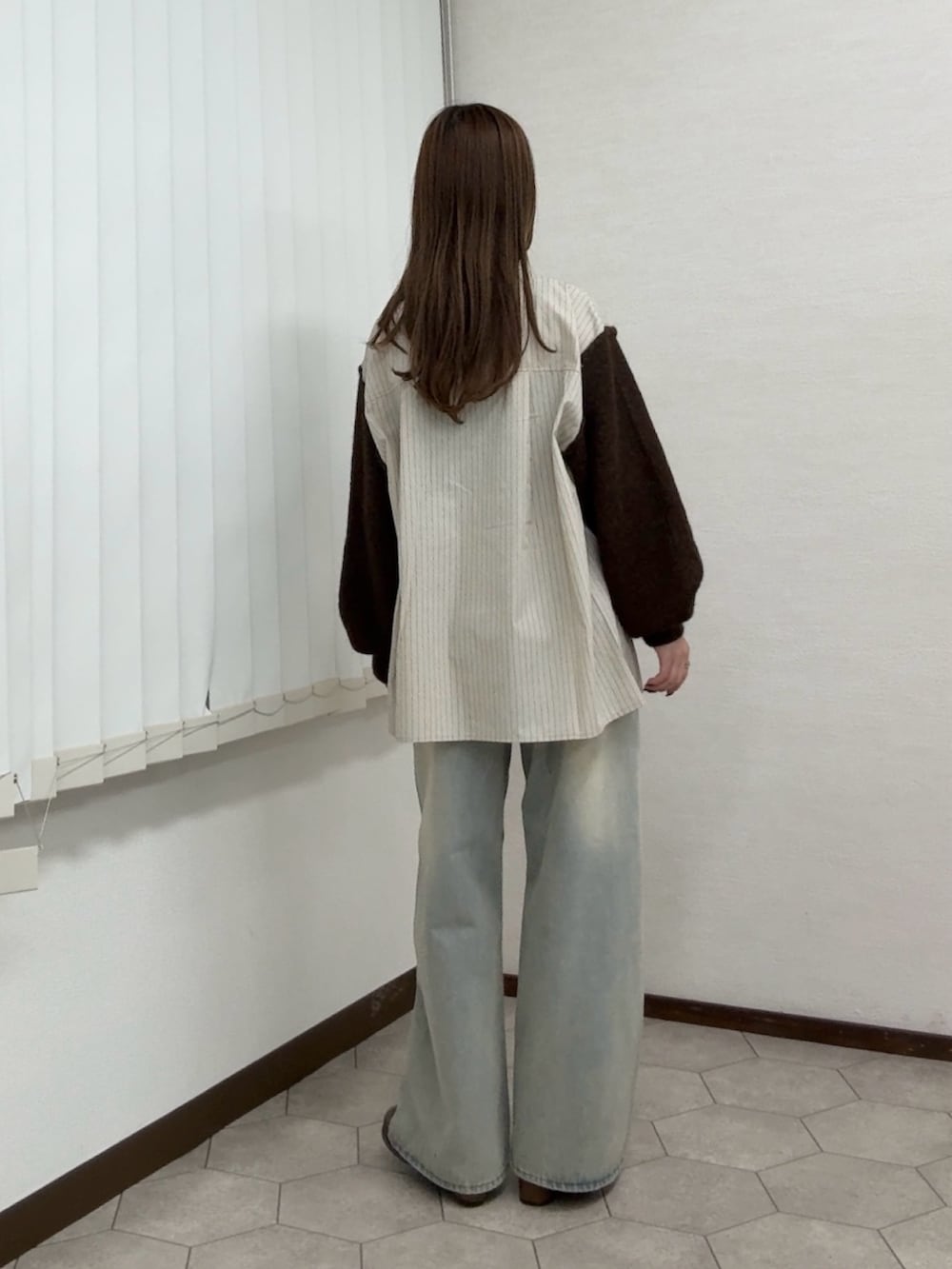 ベージュ系のシャツ/ブラウス、ブルー系のデニムパンツ、ブラウン系のサンダルを着用したレディースの秋コーディネートの3枚目の写真