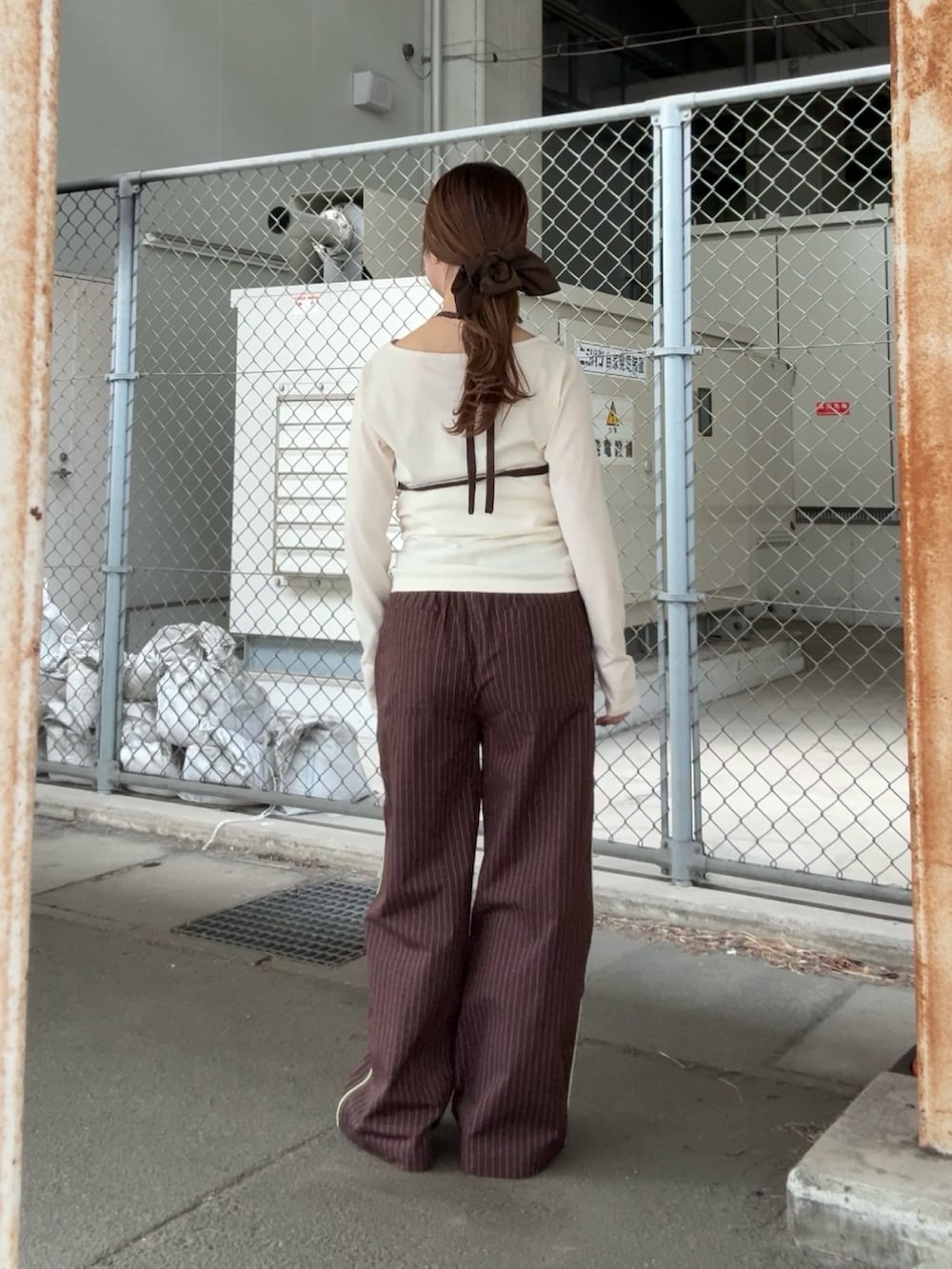 ホワイト系のTシャツ/カットソー、ブラウン系のその他パンツ、グリーン系のヘアゴムを着用したレディースの冬コーディネートの3枚目の写真