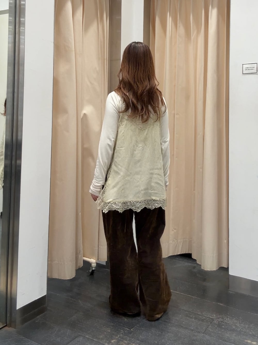 ホワイト系のTシャツ/カットソー、ベージュ系のキャミソール、ブラウン系のデニムパンツを着用したレディースの冬コーディネートの3枚目の写真