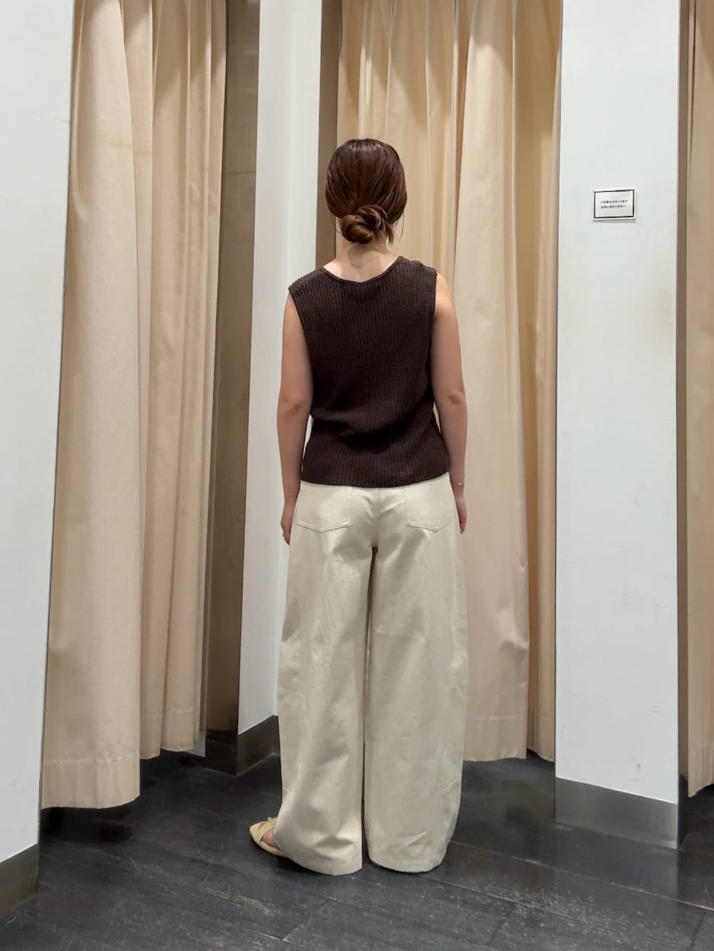 ブラウン系のベスト、ホワイト系のその他パンツ、イエロー系のサンダルを着用したレディースの夏コーディネートの3枚目の写真