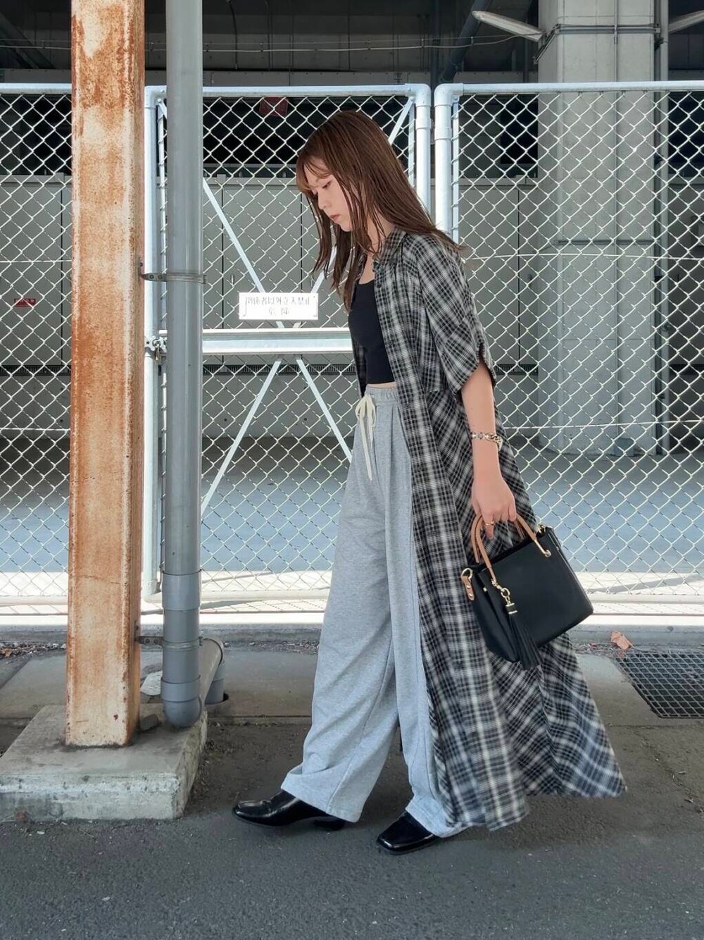 ブラック系のトートバッグ、グレー系のその他パンツ、ブラック系のワンピースを着用したレディースの夏コーディネートの3枚目の写真