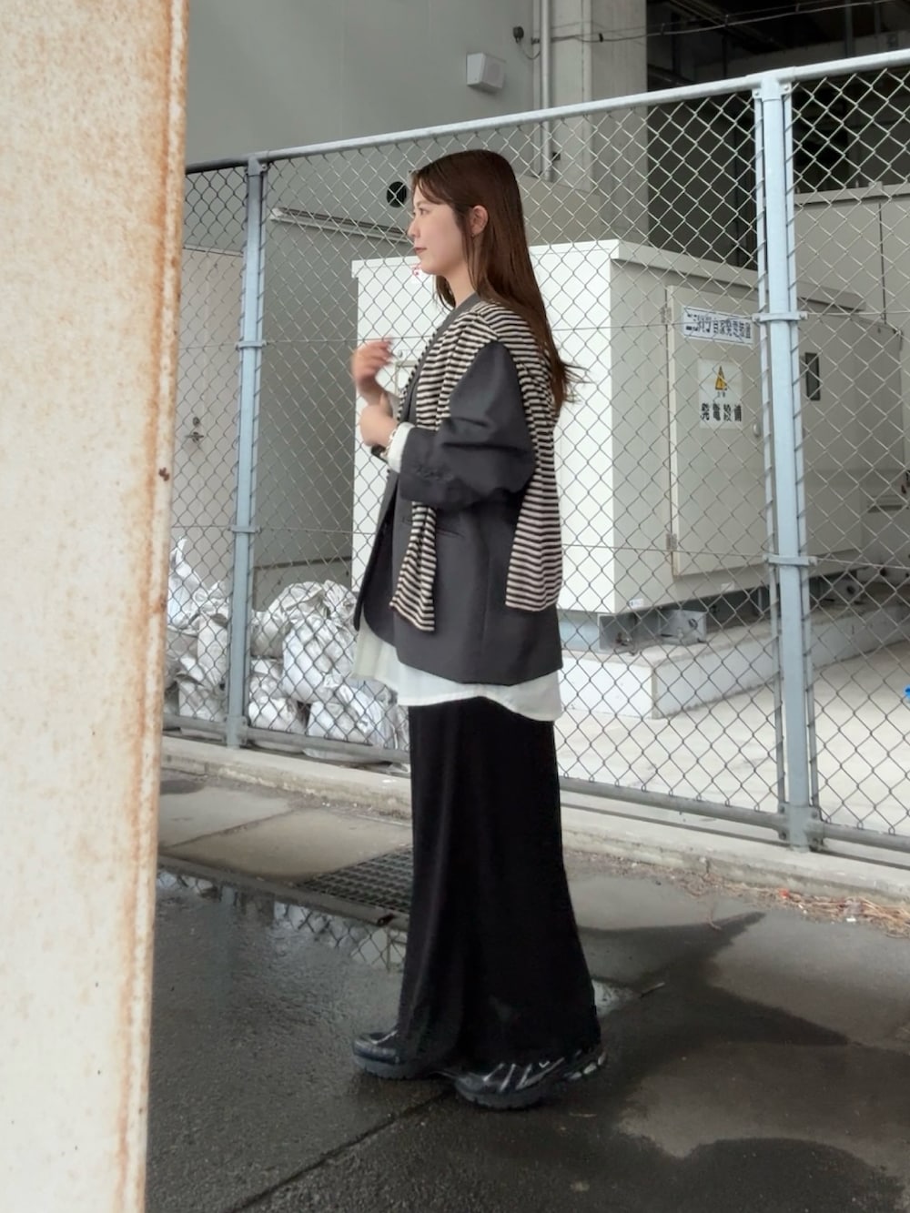 ブラウン系のニット/セーター、グレー系のその他アウター、ブラック系のスカートを着用したレディースの春コーディネートの2枚目の写真