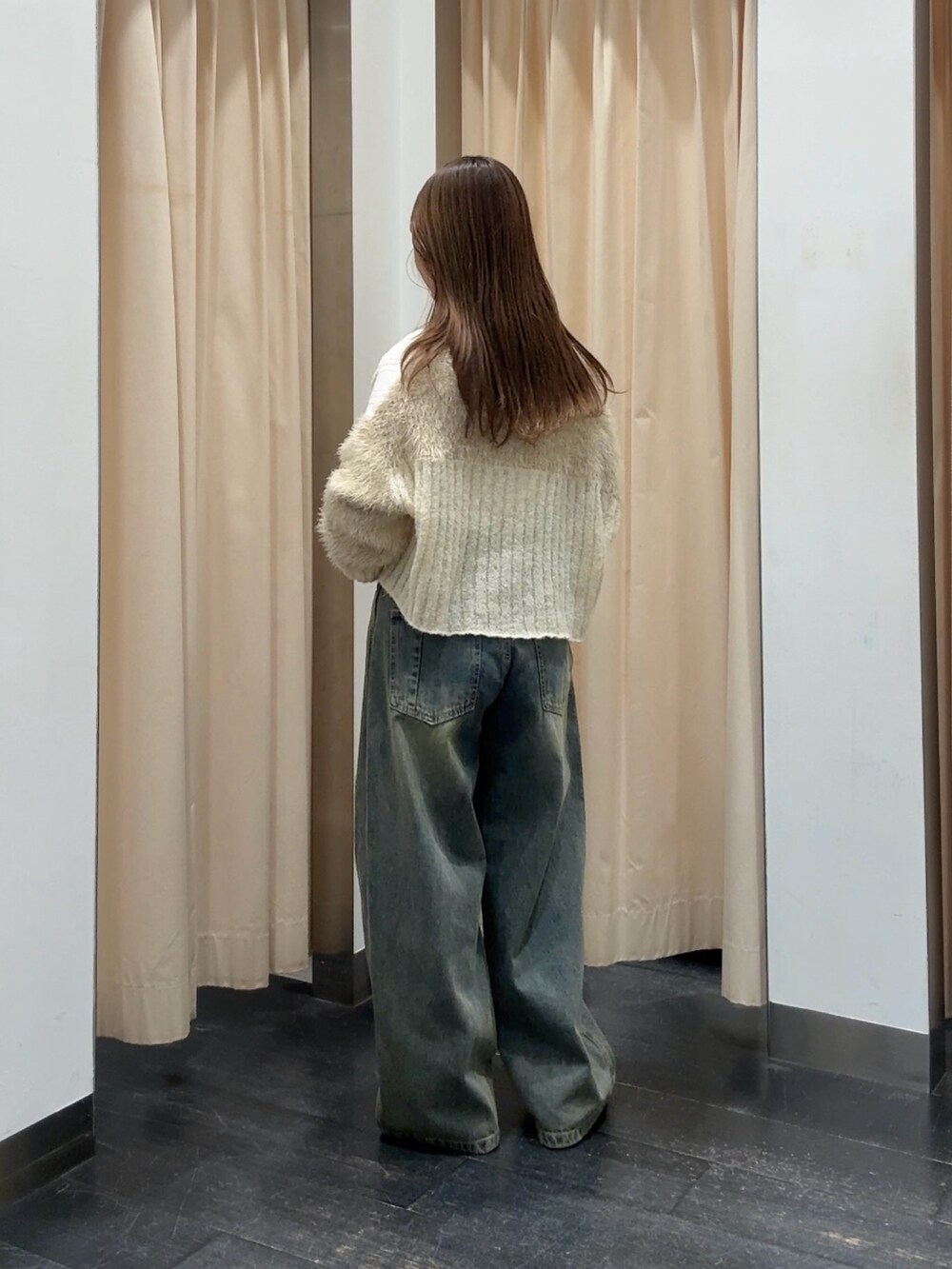 ホワイト系のニット/セーター、ホワイト系のカーディガン/ボレロ、ブルー系のデニムパンツを着用したレディースの秋コーディネートの3枚目の写真