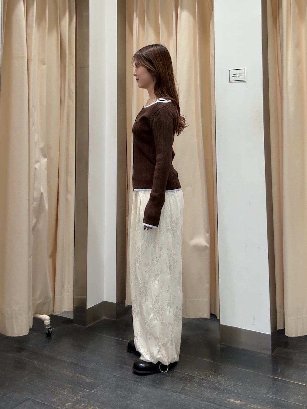 ブラウン系のニット/セーター、ホワイト系のその他パンツ、ブラック系のサンダルを着用したレディースの冬コーディネートの2枚目の写真