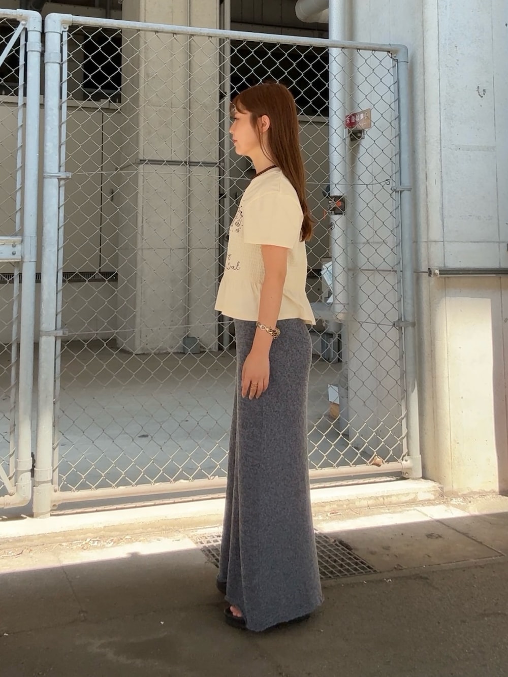 ホワイト系のTシャツ/カットソー、ブルー系のスカート、ブラウン系のネックレスを着用したレディースの夏コーディネートの2枚目の写真
