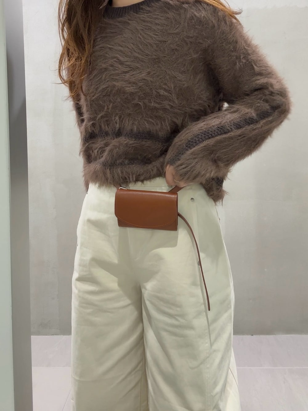 ブラウン系のニット/セーター、ホワイト系のその他パンツ、ブラウン系のスニーカーを着用したレディースの秋コーディネートの4枚目の写真