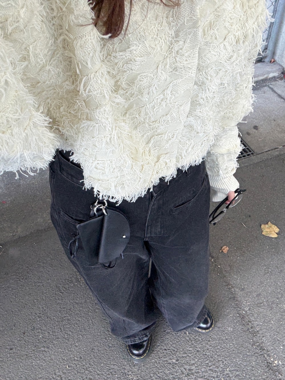 ホワイト系のカーディガン/ボレロ、ブラック系のデニムパンツ、ブラック系のショルダーバッグを着用したレディースの冬コーディネートの5枚目の写真