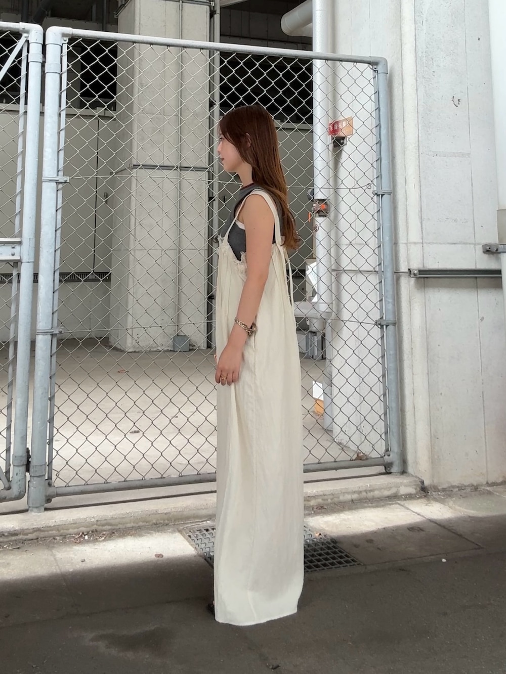 グレー系のタンクトップ、ホワイト系のその他パンツ、レッド系のネックレスを着用したレディースの夏コーディネートの2枚目の写真