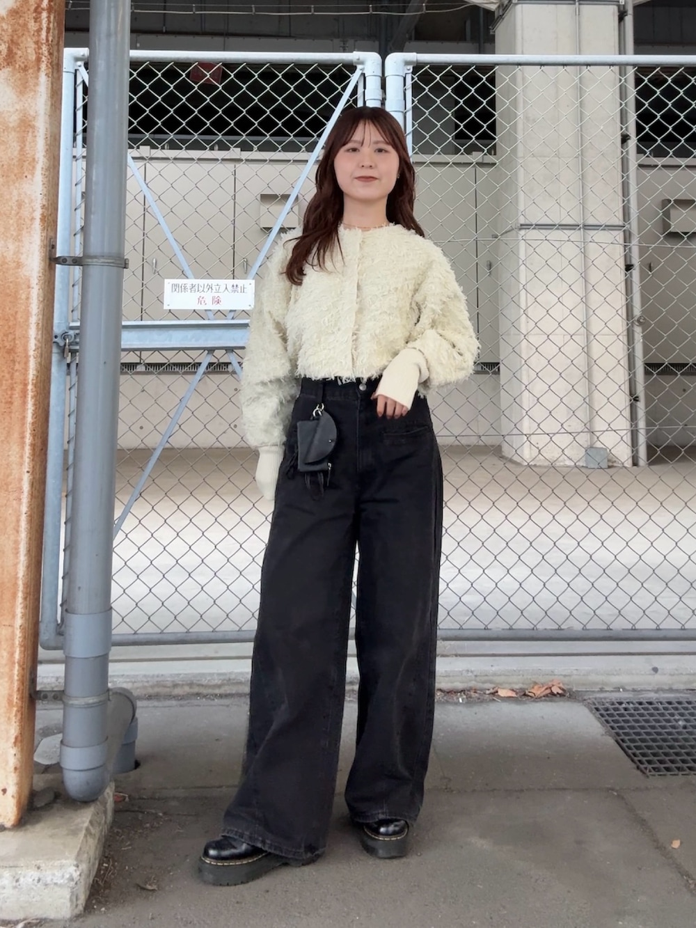 ホワイト系のカーディガン/ボレロ、ブラック系のデニムパンツ、ブラック系のショルダーバッグを着用したレディースの冬コーディネートの2枚目の写真