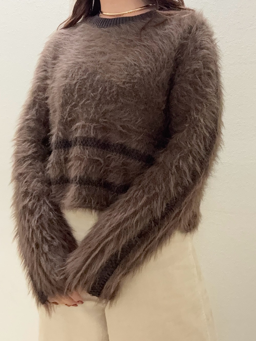 ブラウン系のニット/セーター、ホワイト系のその他パンツ、ベージュ系のその他シューズを着用したレディースの冬コーディネートの4枚目の写真