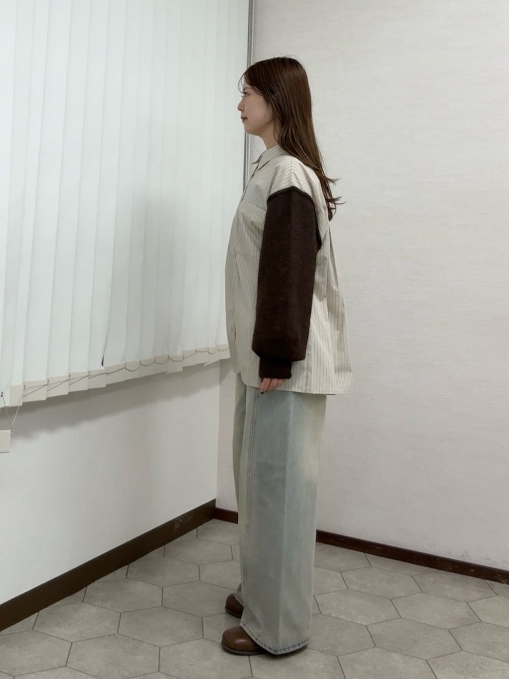 ベージュ系のシャツ/ブラウス、ブルー系のデニムパンツ、ブラウン系のサンダルを着用したレディースの秋コーディネートの2枚目の写真
