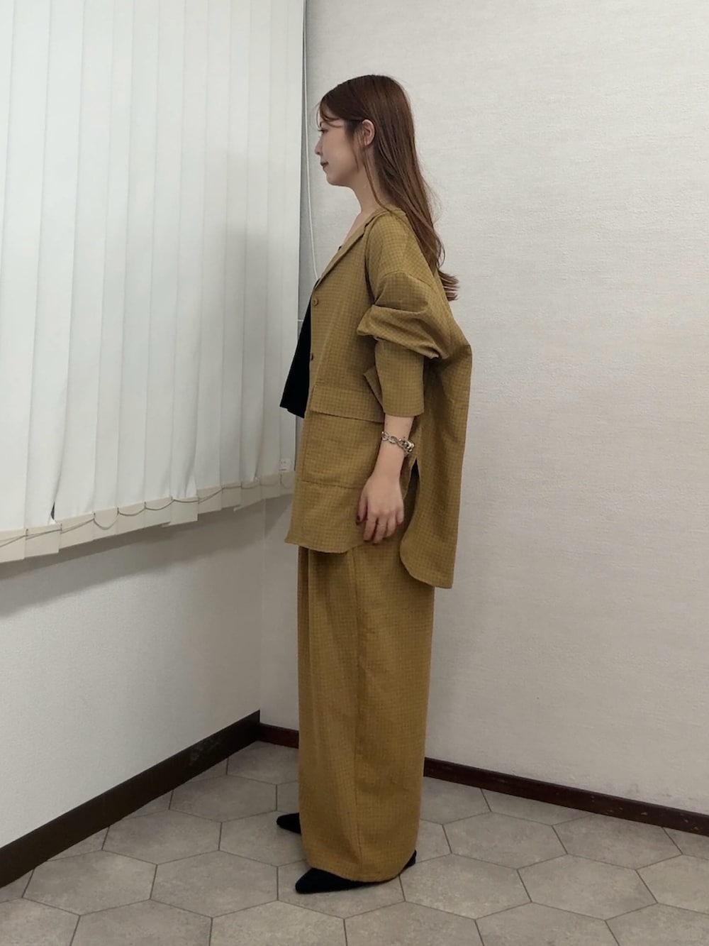 イエロー系のシャツ/ブラウス、イエロー系のその他パンツ、ブラック系のセットアップを着用したレディースの秋コーディネートの2枚目の写真