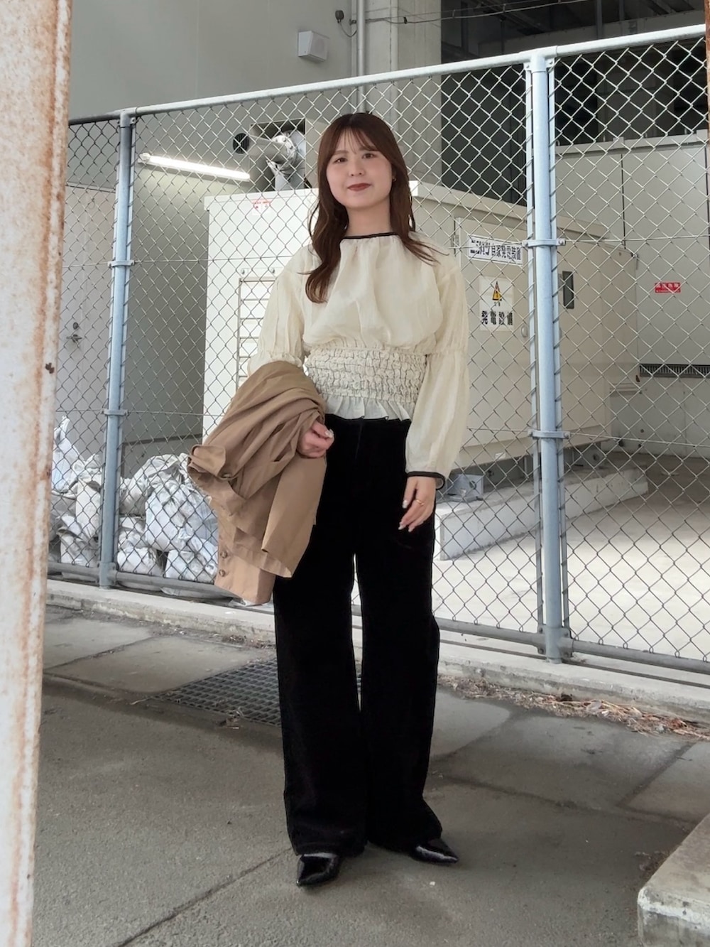 ベージュ系のステンカラーコート、ホワイト系のシャツ/ブラウス、ブラック系のデニムパンツを着用したレディースの冬コーディネートの2枚目の写真