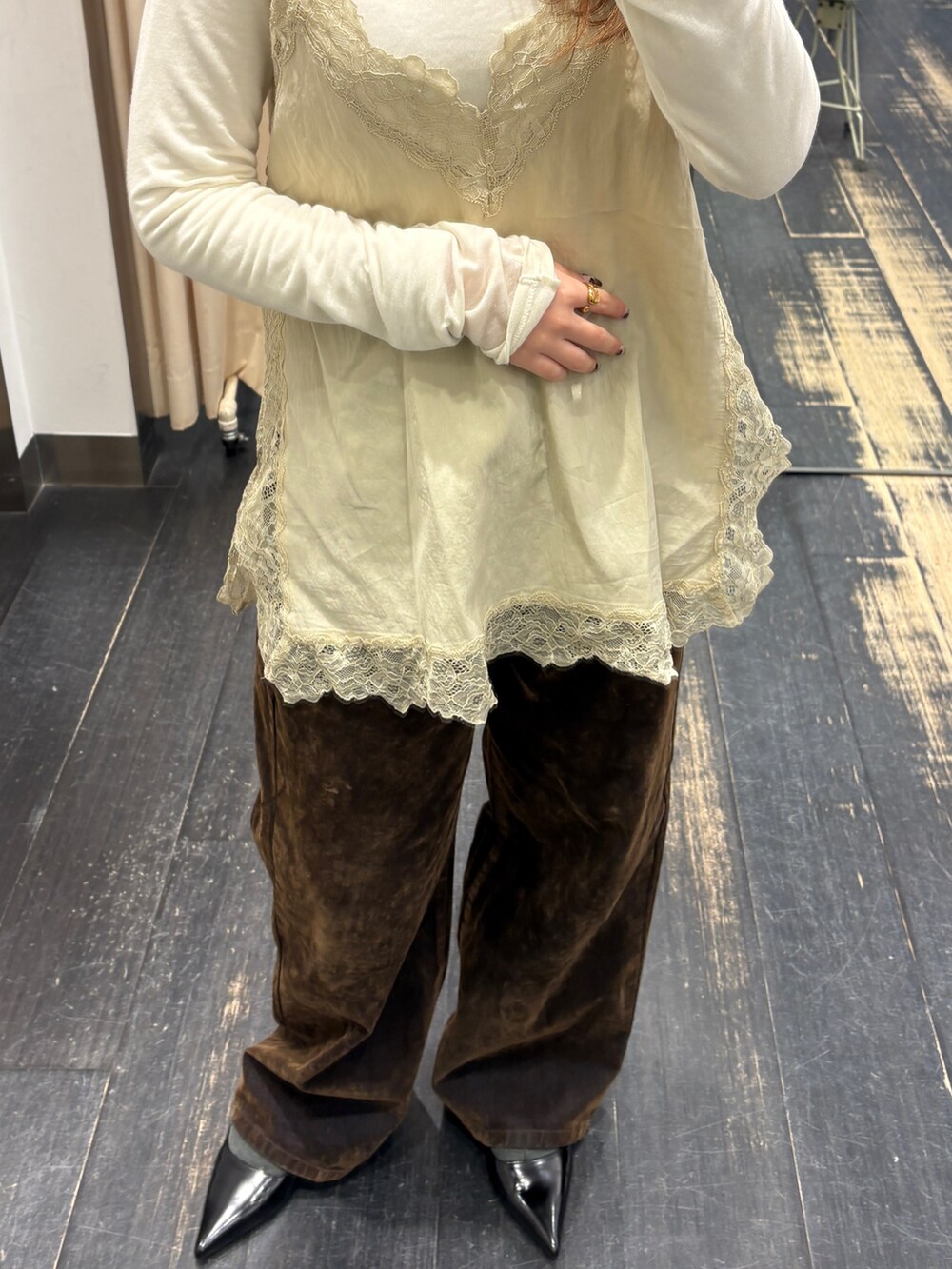 ホワイト系のTシャツ/カットソー、ベージュ系のキャミソール、ブラウン系のデニムパンツを着用したレディースの冬コーディネートの4枚目の写真