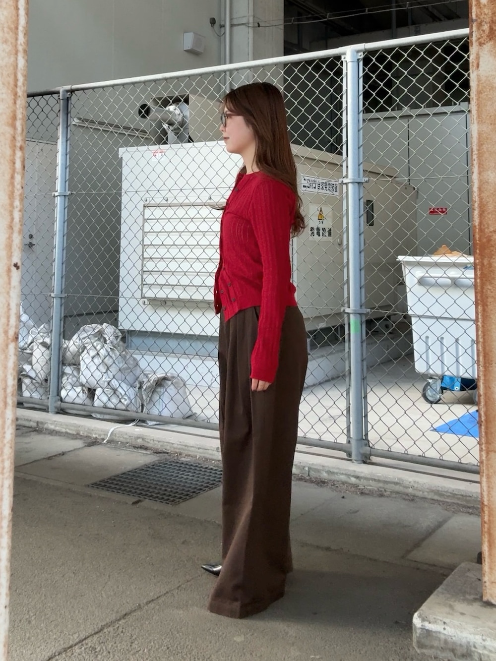 ブラウン系のその他パンツ、レッド系のニット/セーター、ブラウン系のメガネを着用したレディースの春コーディネートの2枚目の写真