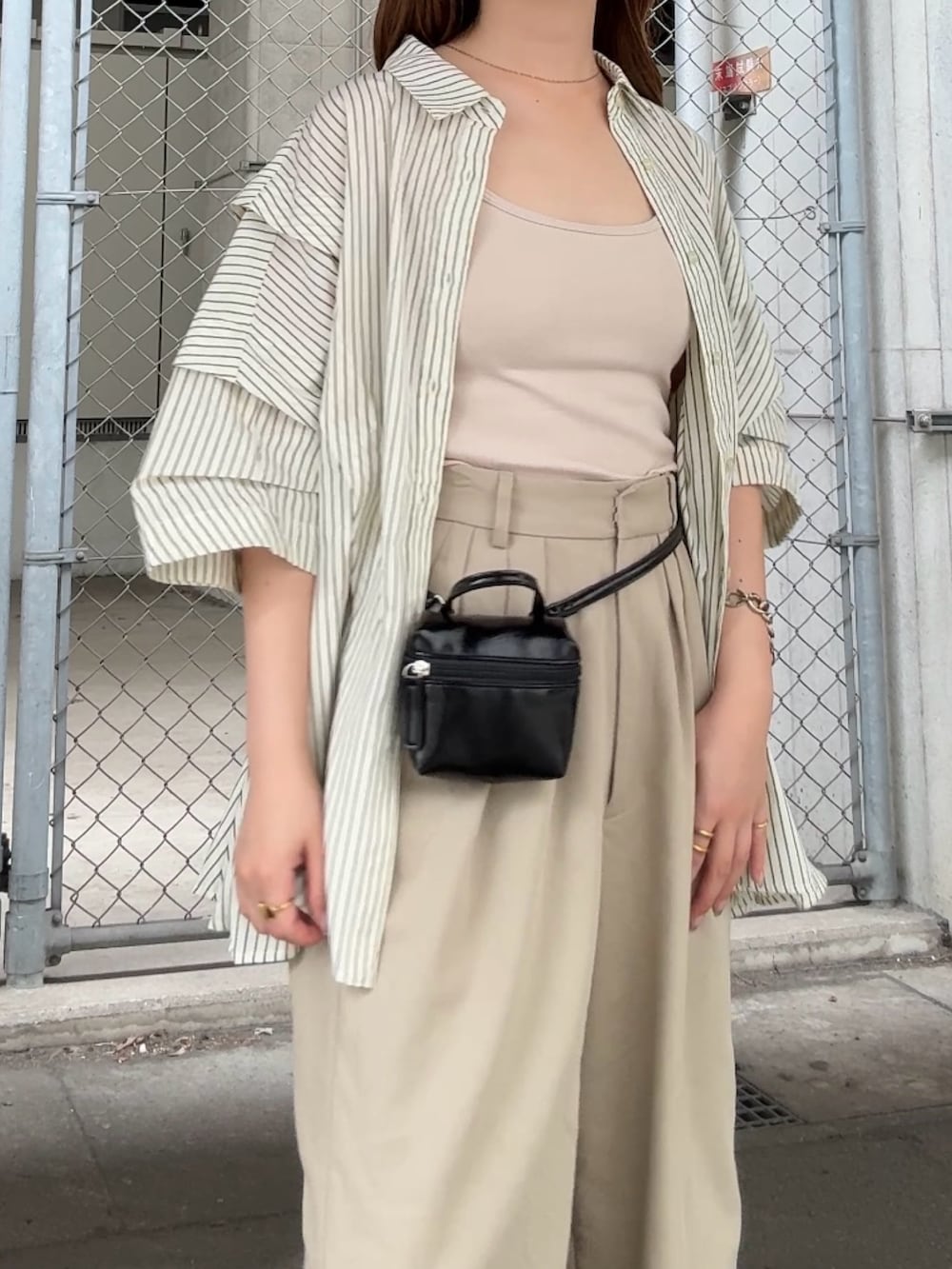 グリーン系のシャツ/ブラウス、ベージュ系のその他パンツ、ブラック系のショルダーバッグを着用したレディースの夏コーディネートの4枚目の写真