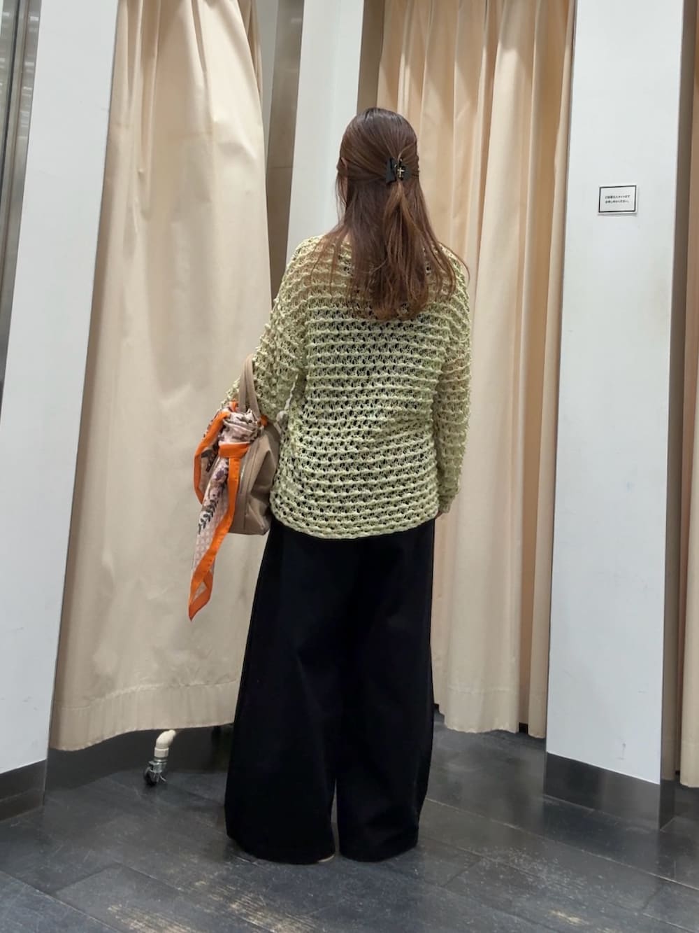 グリーン系のニット/セーター、ブラック系のその他パンツ、ベージュ系のボストンバッグを着用したレディースの春コーディネートの3枚目の写真