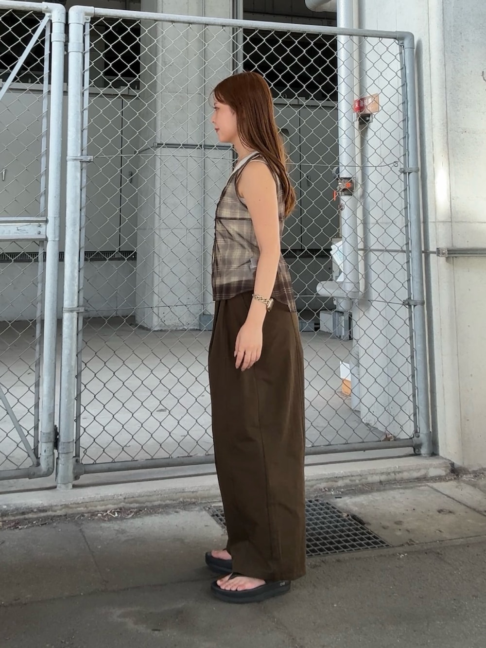 グリーン系のタンクトップ、ブラウン系のその他パンツを着用したレディースの夏コーディネートの2枚目の写真