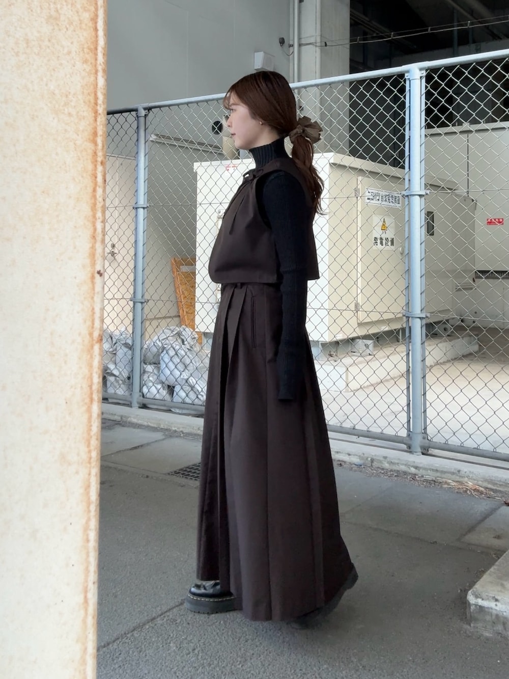 ブラウン系のワンピース、グレー系のニット/セーター、ブラウン系のヘアゴムを着用したレディースの冬コーディネートの2枚目の写真