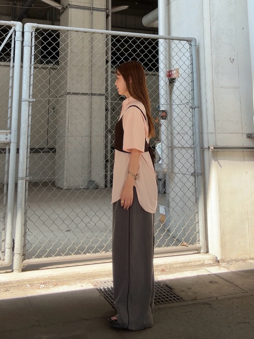 ピンク系のシャツ/ブラウス、グレー系のその他パンツ、ブラウン系のヘアゴムを着用したレディースの夏コーディネートの2枚目の写真