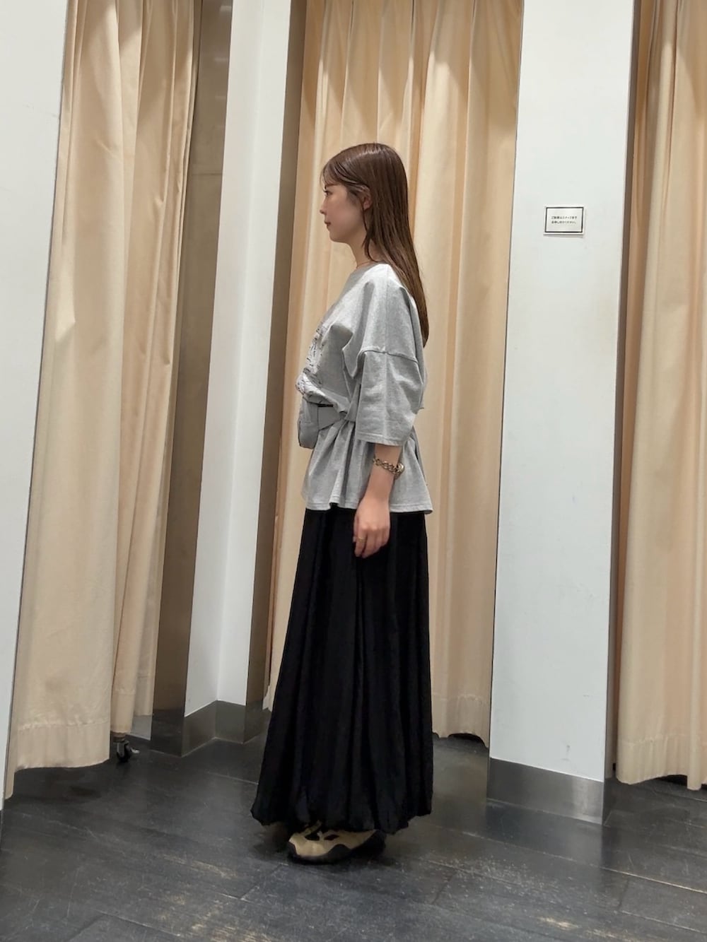 グレー系のTシャツ/カットソー、ブラック系のスカート、ベージュ系のスニーカーを着用したレディースの春コーディネートの2枚目の写真