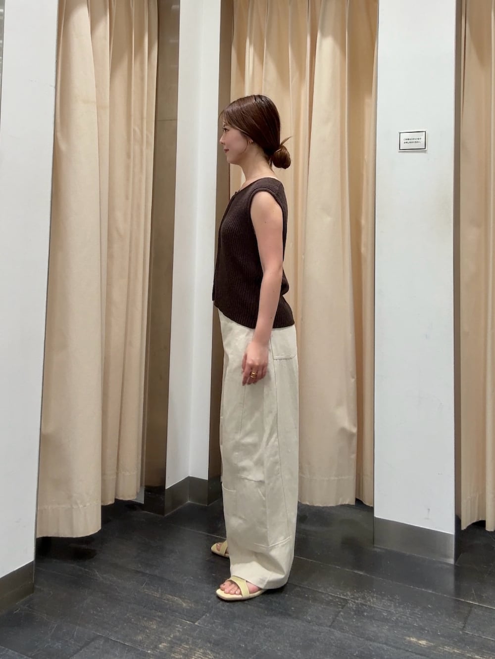 ブラウン系のベスト、ホワイト系のその他パンツ、イエロー系のサンダルを着用したレディースの夏コーディネートの2枚目の写真