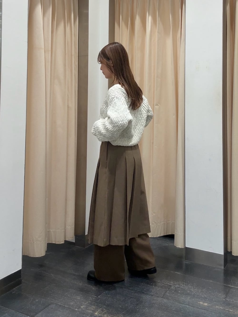 ホワイト系のニット/セーター、ブラウン系のスカート、ブラウン系のその他パンツを着用したレディースの秋コーディネートの3枚目の写真