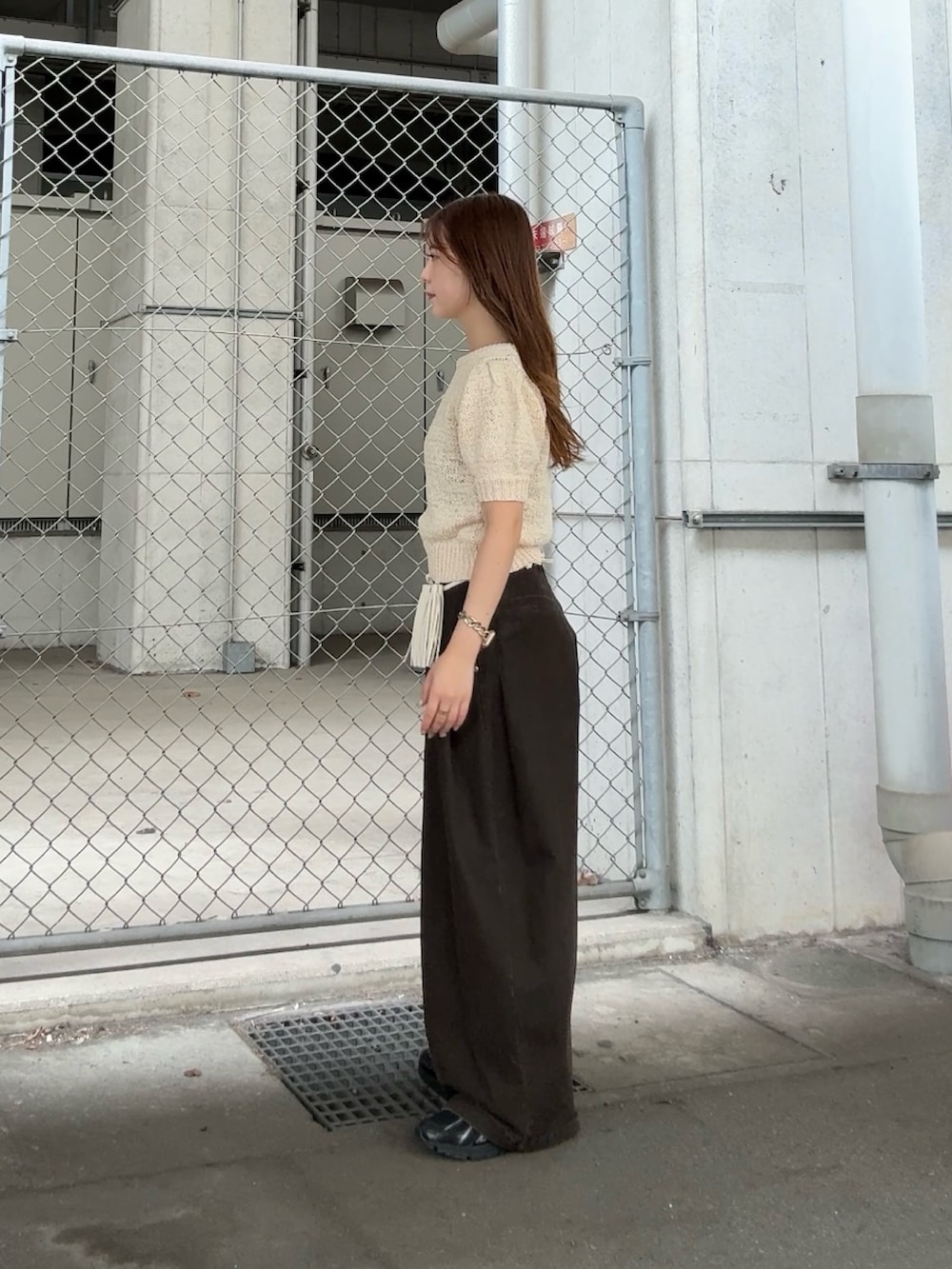 ホワイト系のニット/セーター、グレー系のその他パンツ、ホワイト系のポーチを着用したレディースの夏コーディネートの2枚目の写真