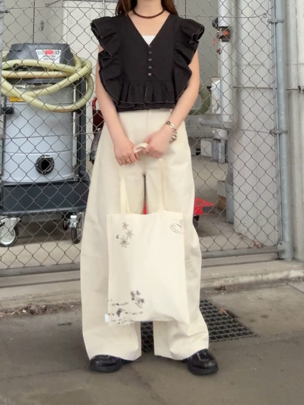 ブラック系のシャツ/ブラウス、ホワイト系のその他パンツ、ブラウン系のネックレスを着用したレディースの春コーディネートの4枚目の写真