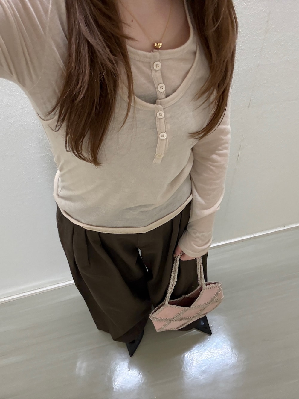 ピンク系のショルダーバッグ、ベージュ系のTシャツ/カットソー、ブラウン系のその他パンツを着用したレディースの春コーディネートの4枚目の写真