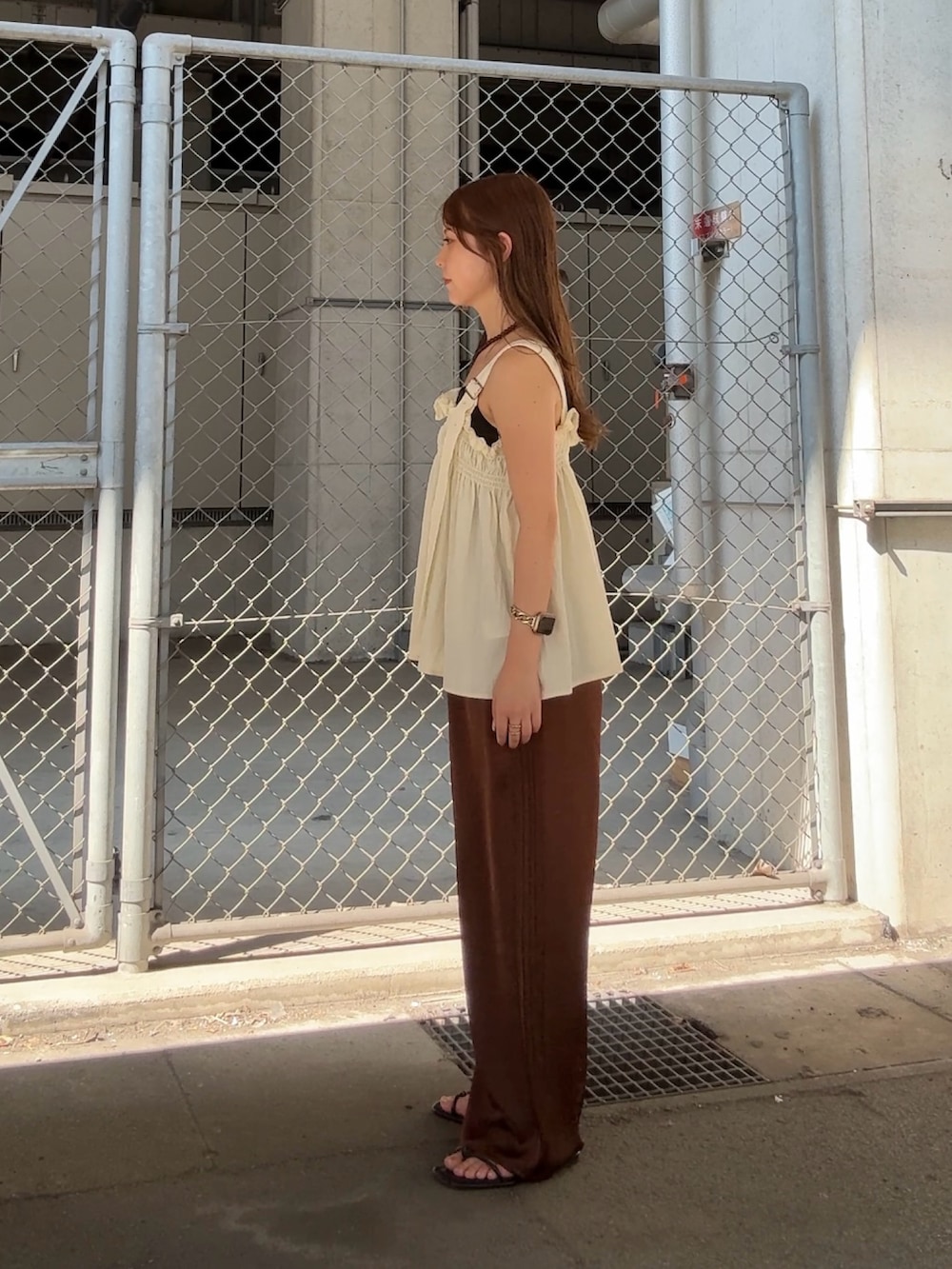 ホワイト系のその他トップス、ブラウン系のその他パンツ、ブラウン系のネックレスを着用したレディースの夏コーディネートの2枚目の写真